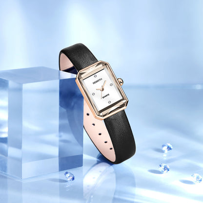 Watch with black leather strap and rose gold case on a reflective blue surface