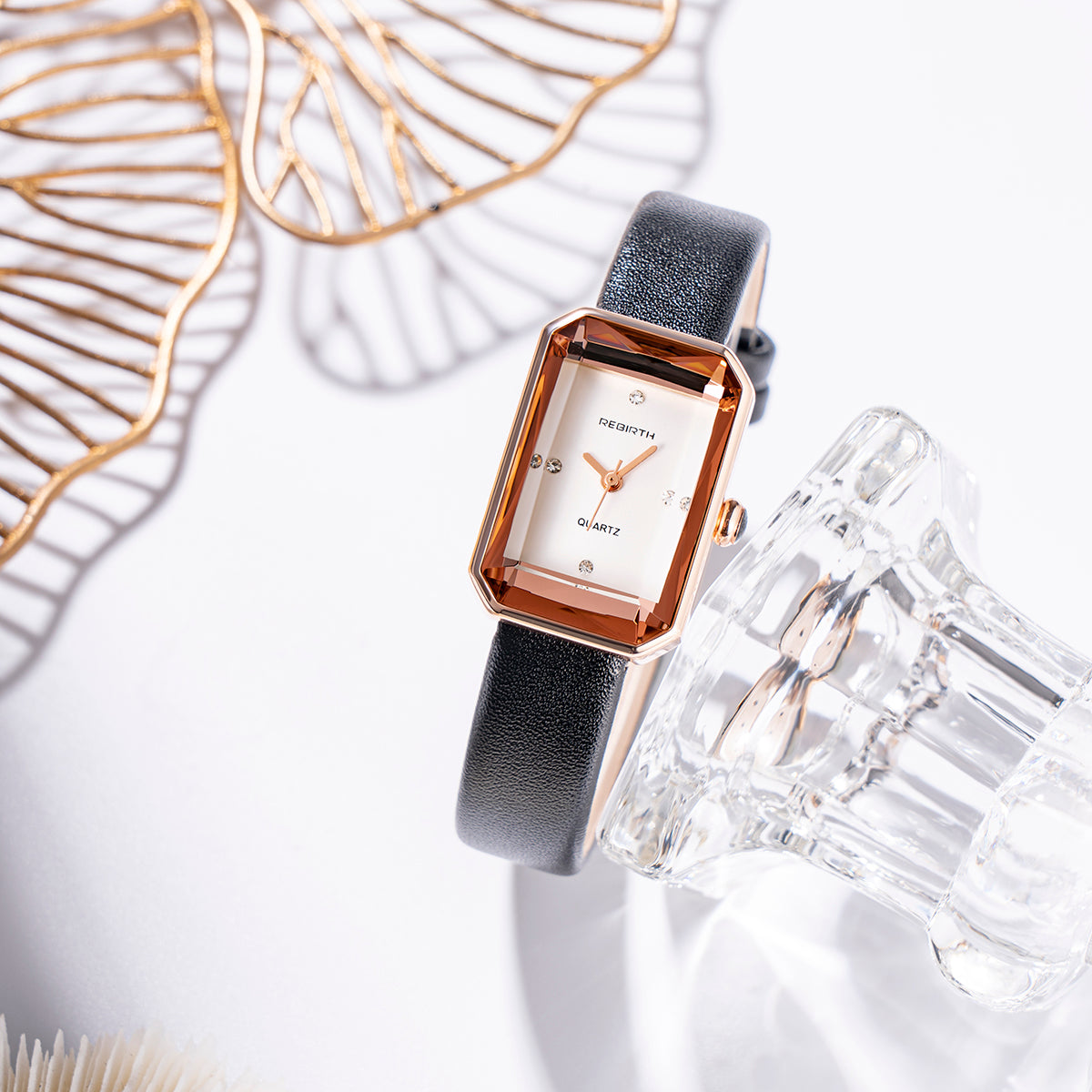 Luxury watch with a black strap and gold accents on a white background
