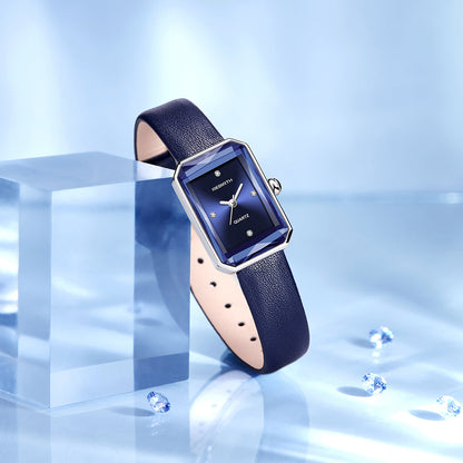 Blue watch with a rectangular face on a reflective blue surface