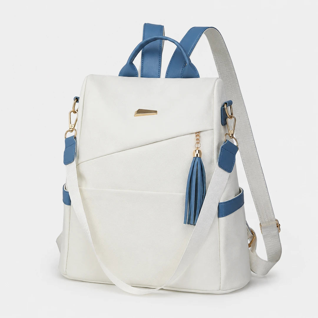 Josh & Tate - AntiTheft™ Oxford Backpack - A white backpack with blue accents, including blue handles, a blue tassel zipper pull, and blue side pocket trim, shown on a light gray background.