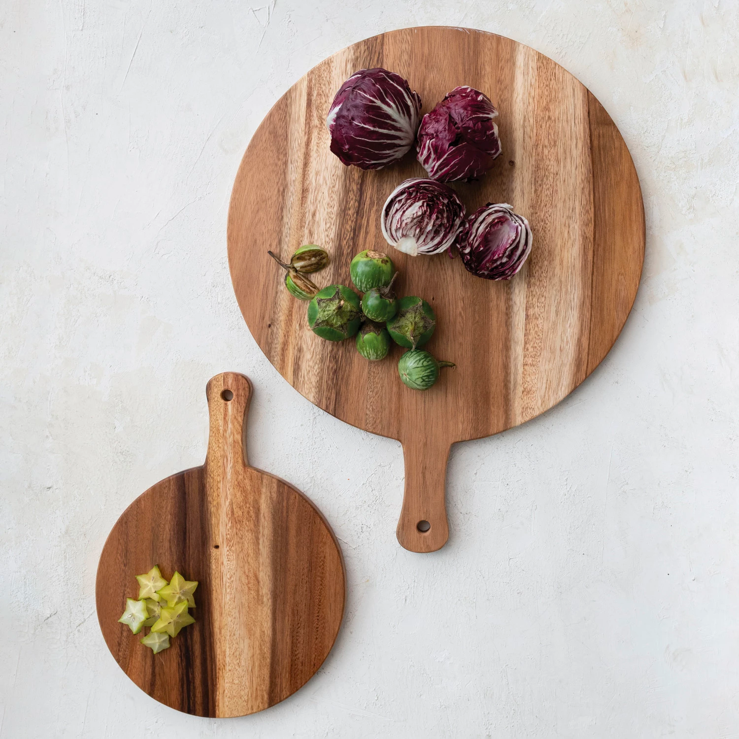 Two wooden cutting boards with vegetables on a light gray background