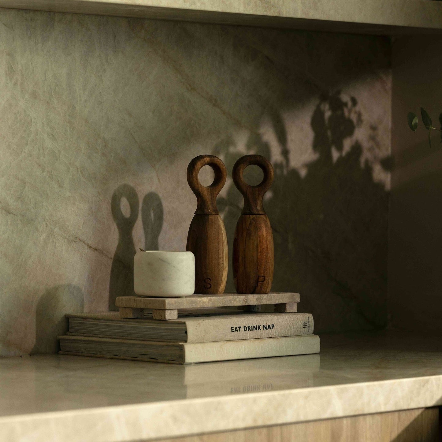 Wooden objects and books on a marble surface with a textured wall background