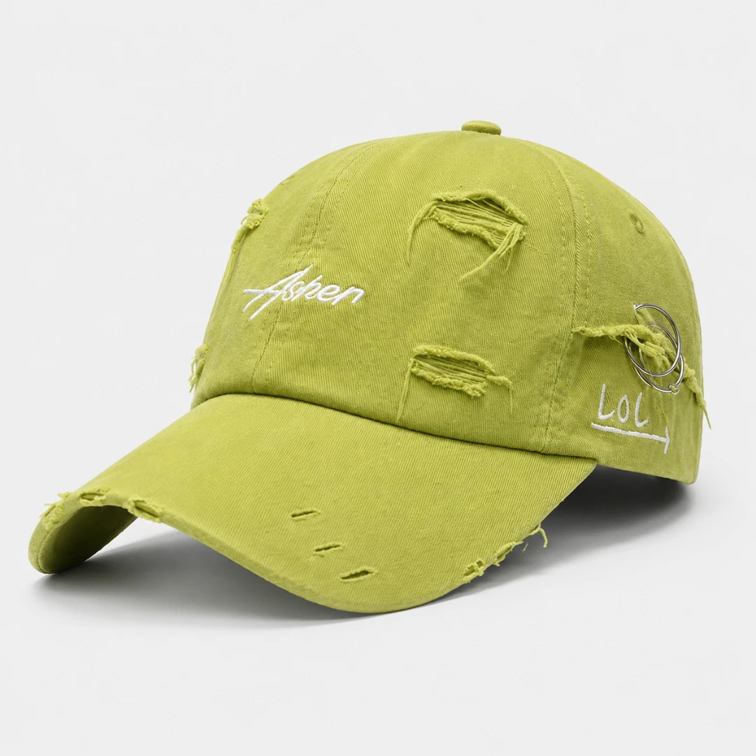 Josh & Tate - AsherLOL™ Distressed Cap - A distressed baseball cap in a muted olive green color, featuring white embroidered text on the front and side, with intentional frayed and ripped details on the fabric.