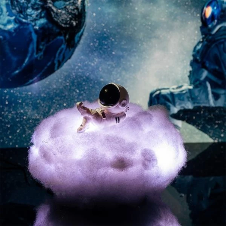 Small astronaut figurine on a fluffy white surface with a space-themed background featuring an astronaut and a planet.
