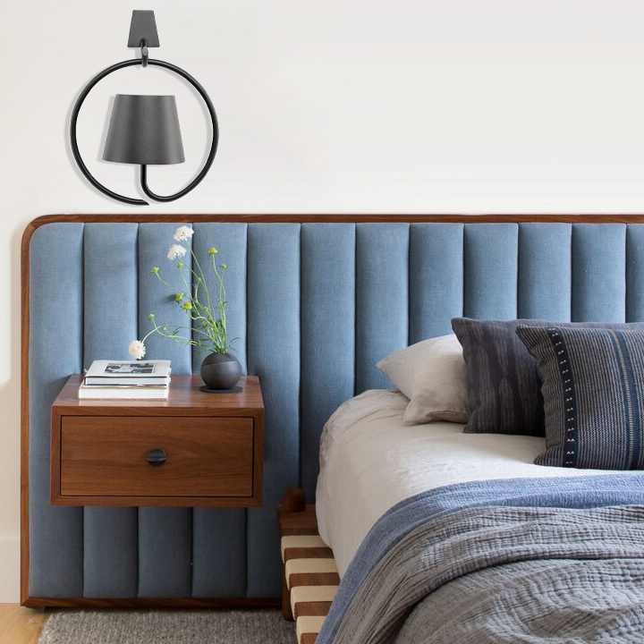 Bedroom with blue upholstered headboard, wooden nightstand, and decorative pillows.