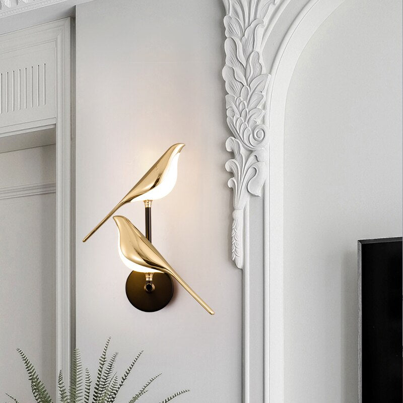 Gold wall sconce on a white wall with decorative molding