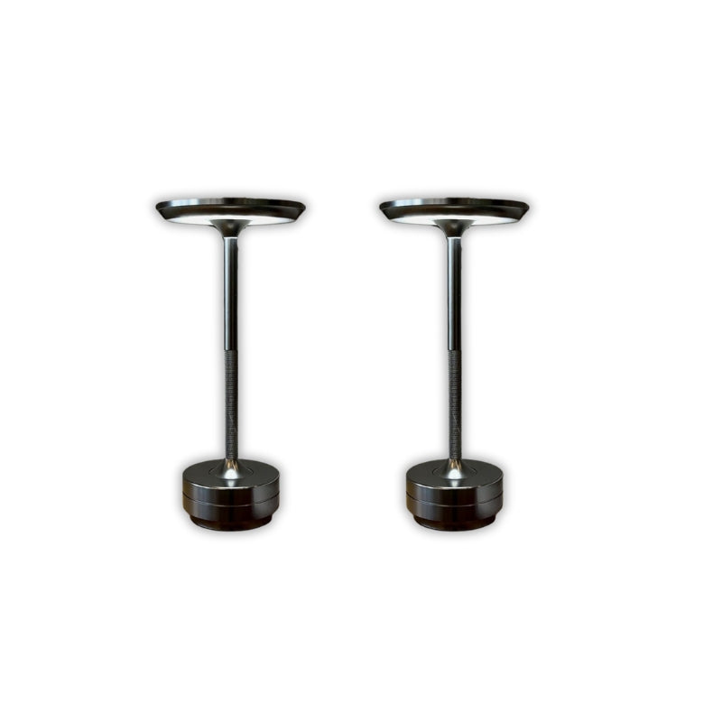 Two black cylindrical objects with metallic tops on a white background