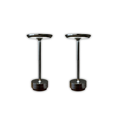 Two black cylindrical objects with metallic tops on a white background