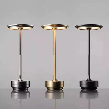 Three portable lamps with different finishes on a reflective surface and gray background