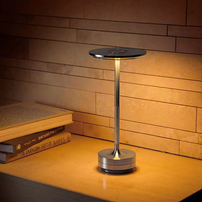Modern desk lamp on a wooden surface with a warm light.
