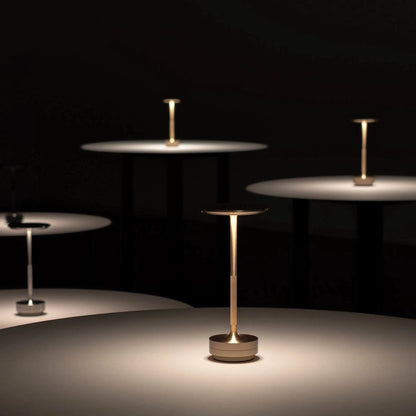 Set of modern side tables with gold and silver finishes on a dark background