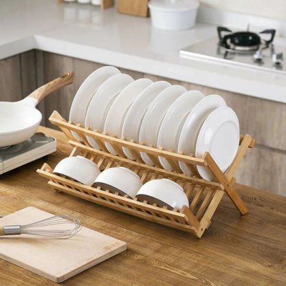 Wooden dish rack with white plates on a kitchen counter