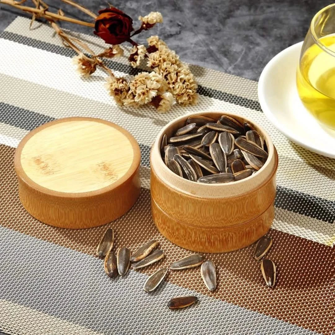Josh & Tate - Bamboo Food Storage Container - Wooden container with sunflower seeds on a textured surface with a cup of tea in the background.