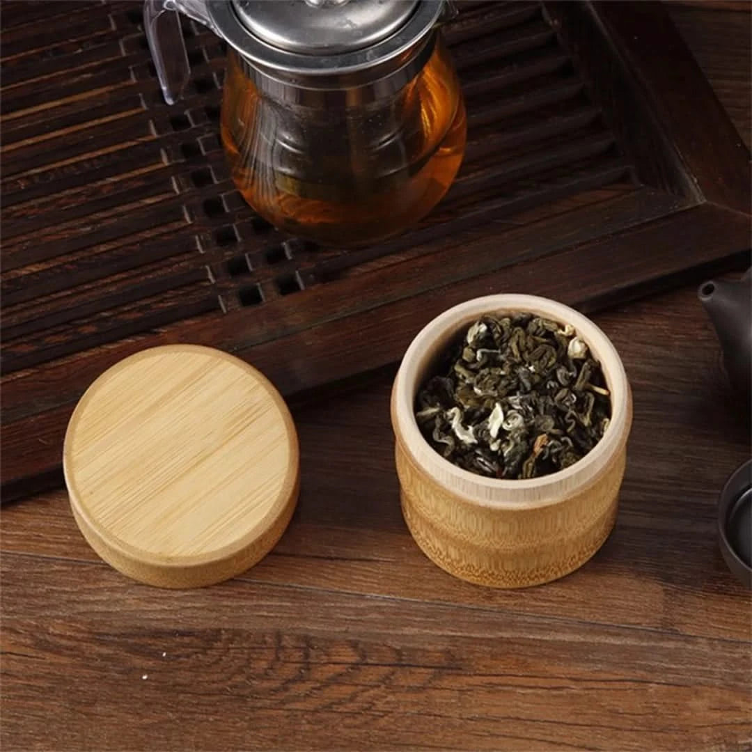 Josh & Tate - Bamboo Food Storage Container - Wooden container with tea leaves and a lid on a wooden surface