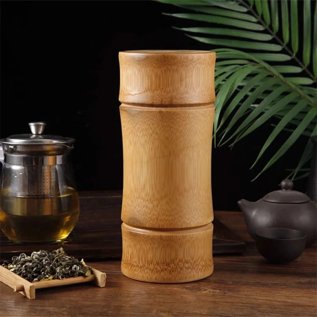 Josh & Tate - Bamboo Food Storage Container - Bamboo tea press with tea leaves and teacup on a wooden surface