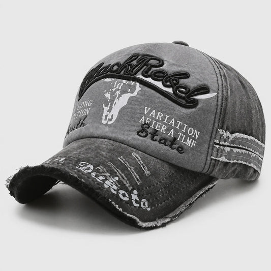 Josh & Tate - BlackRebel™ Distressed Cap - A distressed gray baseball cap with black and white graphic text and embroidery, including 'RustRock' and 'Vartation After A TMR Skate'.
