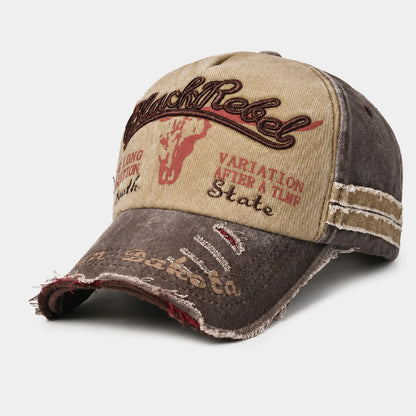 Josh & Tate - BlackRebel™ Distressed Cap - A distressed baseball cap with a beige front panel, dark brown frayed brim, and embroidered text including 'Black Rebel' and 'State' on a light gray background.