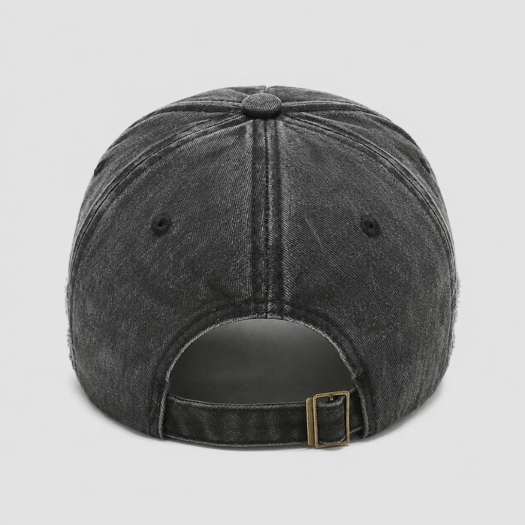 Josh & Tate - BlackRebel™ Distressed Cap - Rear view of a dark gray washed denim baseball cap with an adjustable strap and a gold-tone metal buckle, shown on a light gray background.