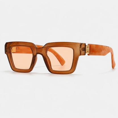 Josh & Tate - BlockFrame™ Bold Square Sunglasses - Square sunglasses with translucent amber-brown frames, peach-tinted lenses, and matching amber temple arms with gold-tone metal hinges, shown on a light gray background.