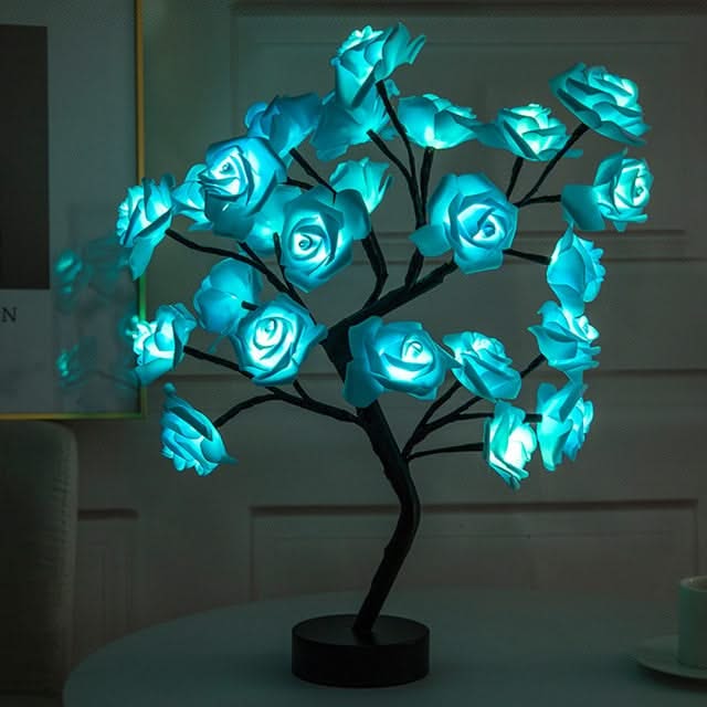Decorative LED tree with blue roses on a dark background