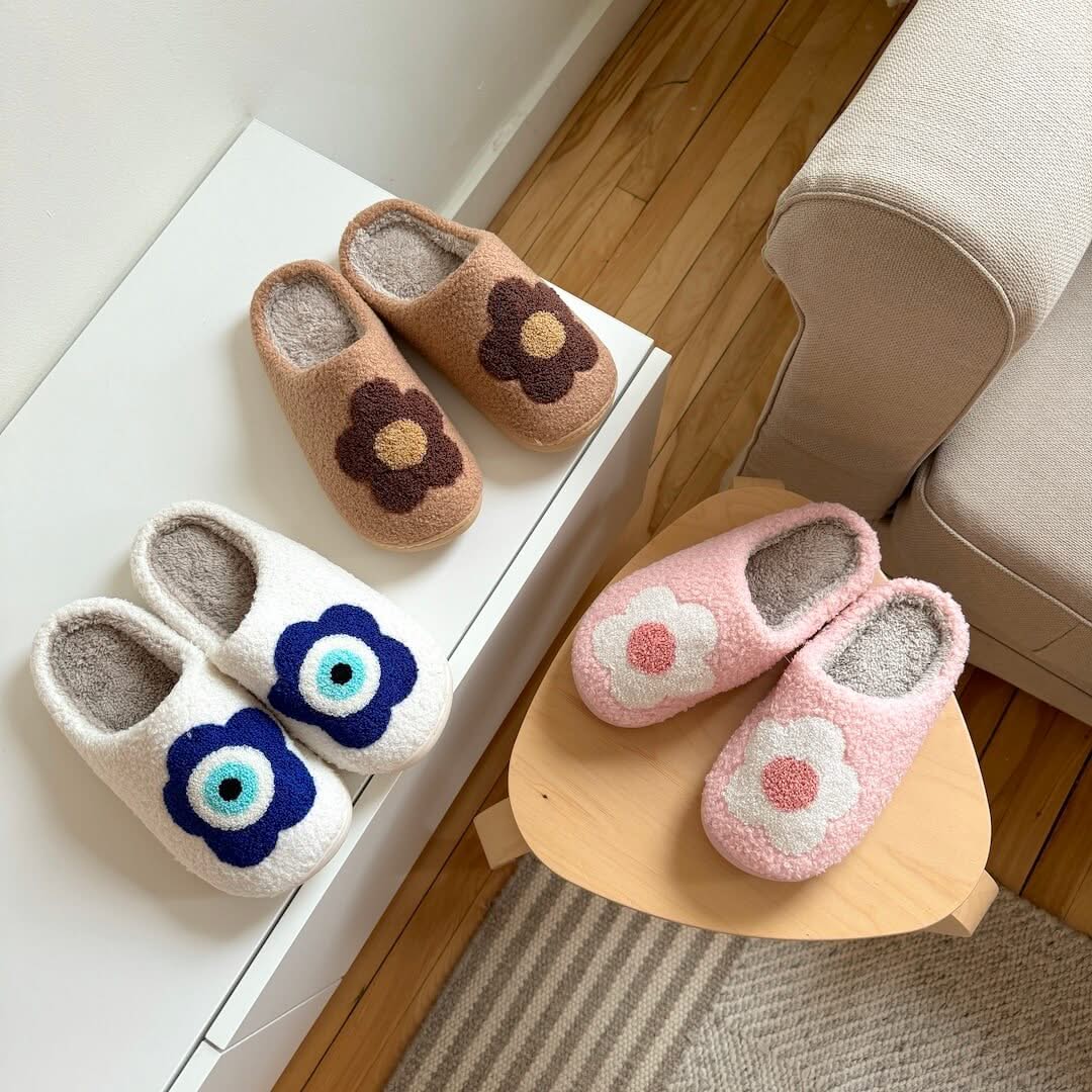 Pair of floral slippers on a wooden stool and surface with a neutral background