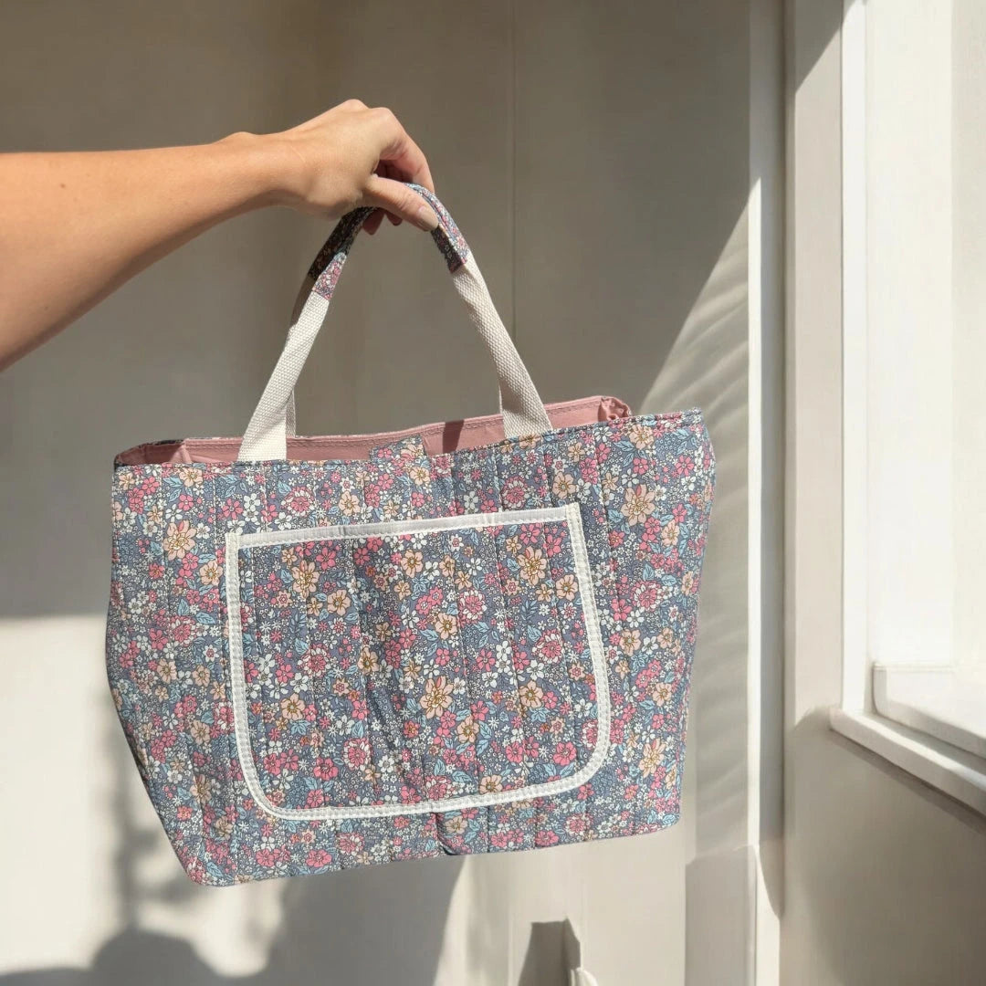 Josh & Tate - Blossom Tote Bag - Person holding a floral-patterned tote bag in a bright room with sunlight streaming in.