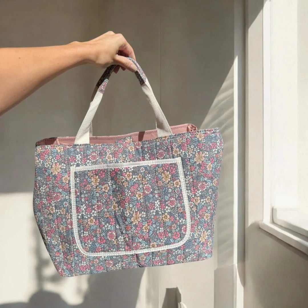 Josh & Tate - Blossom Tote Bag - Person holding a floral-patterned tote bag in a bright room with sunlight streaming in.
