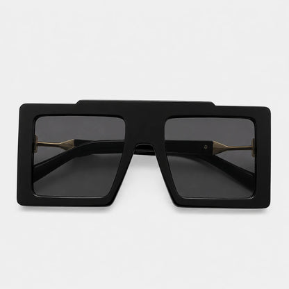 Josh & Tate - BoldFrame™ Square Glasses - Black oversized square sunglasses with dark lenses and gold metal bridge details, shown from a top-down view on a light gray background.