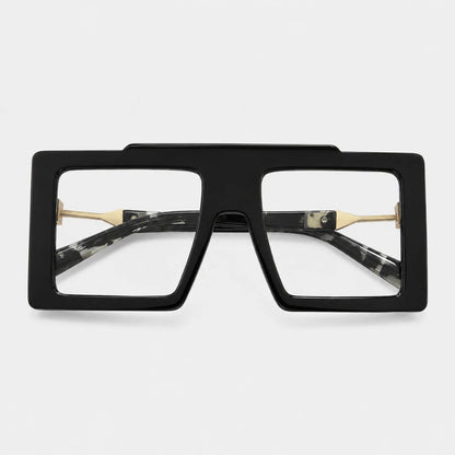 Josh & Tate - BoldFrame™ Square Glasses - A pair of oversized square sunglasses with a thick black front frame, clear lenses, and gold metal hinges, shown against a light gray background.