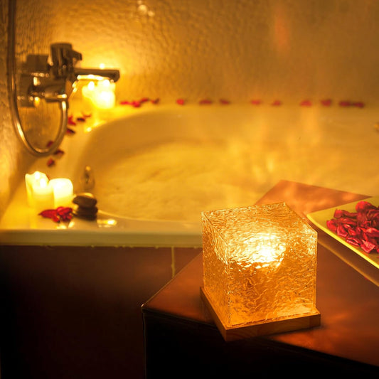 Relaxing bath scene with lit candles and rose petals in a warm, cozy setting.