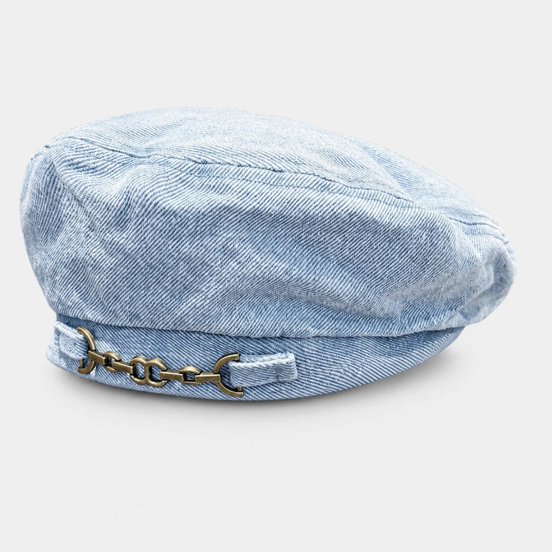 Josh & Tate - BrixChain™ Washed Denim Beret - A light blue denim newsboy cap with a decorative antique bronze horsebit chain detail on the front band, shown against a light gray background.