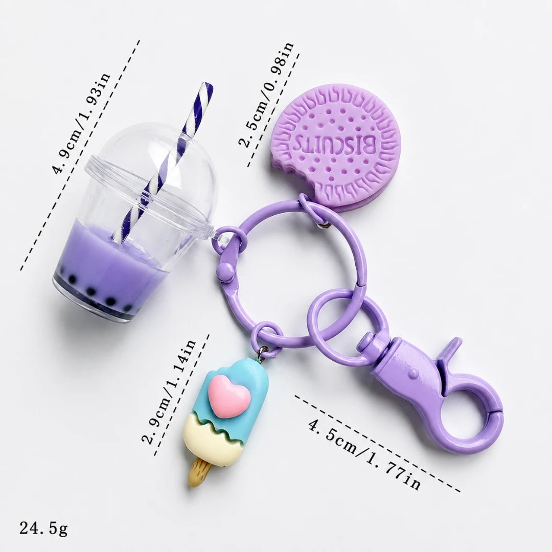 Josh & Tate - BubbleBite™ Milk Tea Keychain - A purple silicone keychain bag set featuring a drink cup charm with a striped straw, a biscuit-shaped bag, and an ice cream cone charm, shown with dimension lines and weight text on a white background.