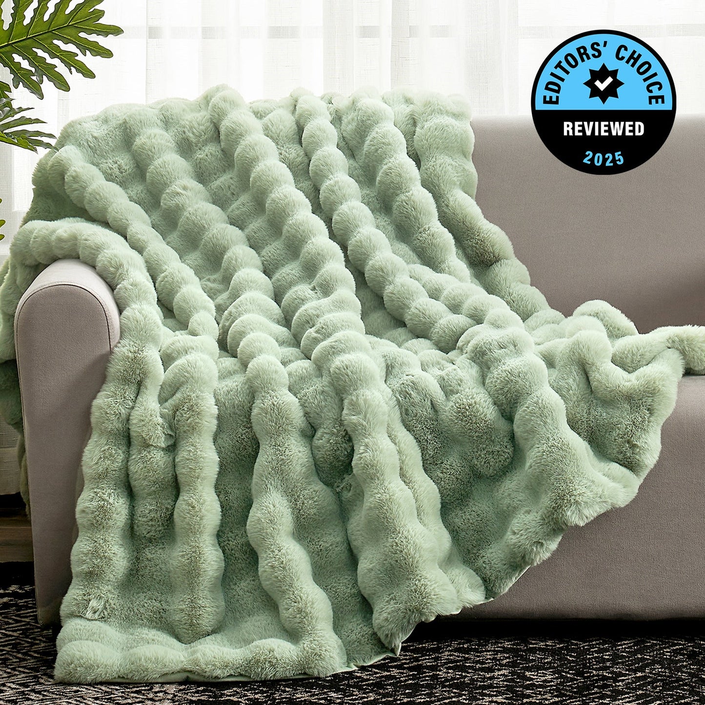 Green textured blanket draped over a couch with 'Editors' Choice' badge in the corner.