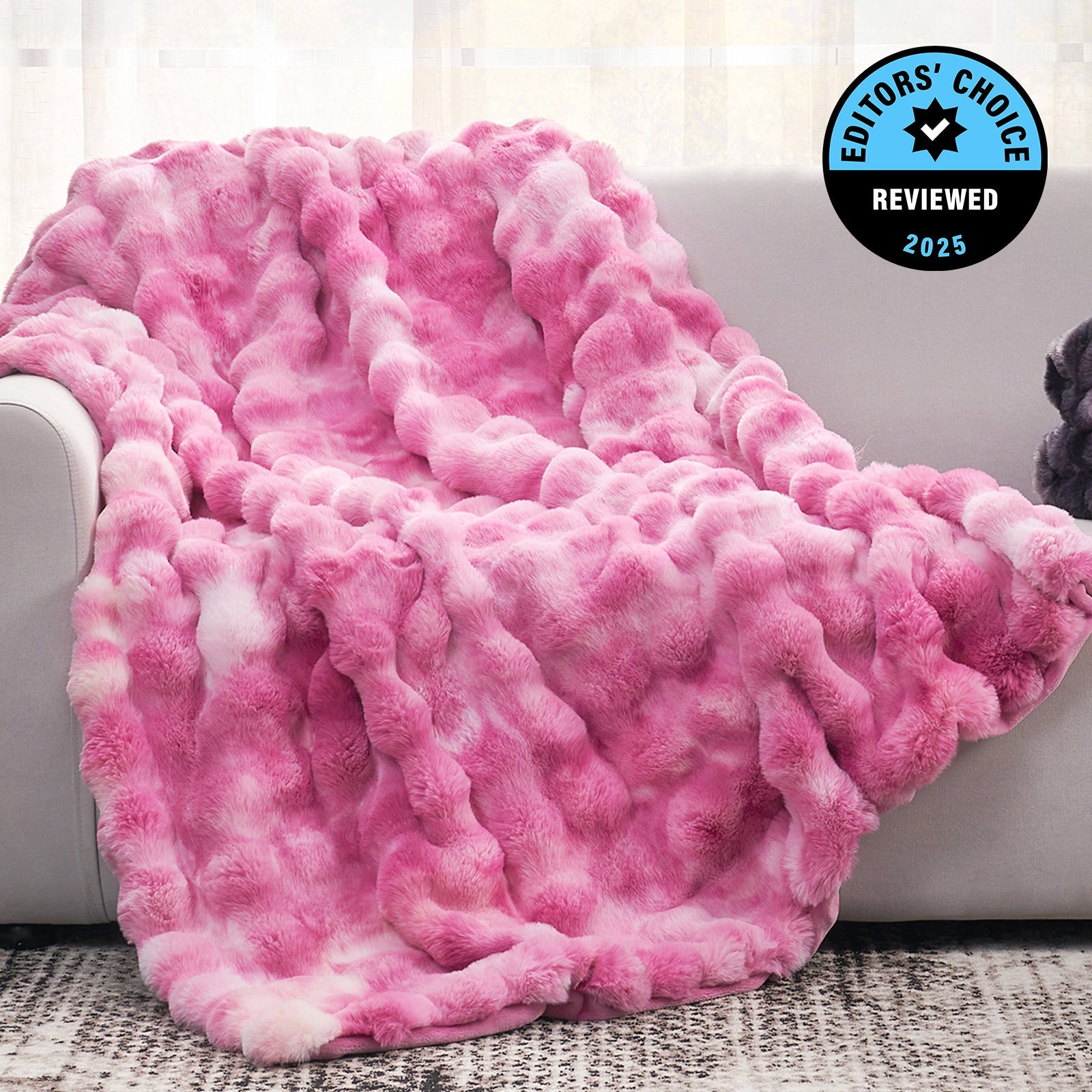 Pink textured blanket draped over a couch with 'Editors' Choice' badge in the corner.