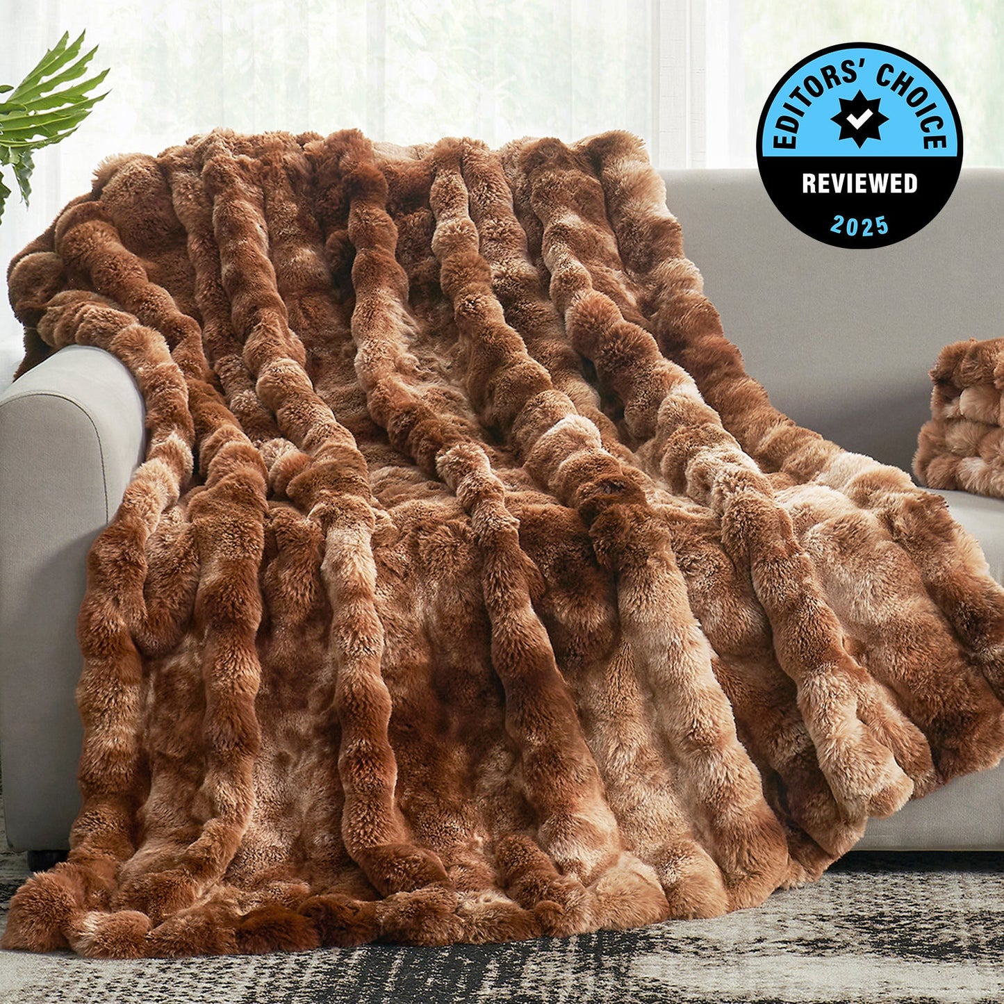 Brown faux fur blanket draped over a sofa with 'Editors' Choice' badge in the corner.