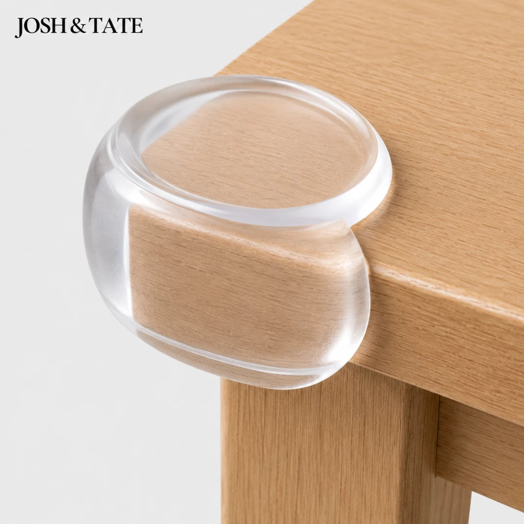Josh & Tate - BumperBall™ Corner Protectors - Clear furniture leg cap on a wooden table with 'JOSH & TATE' branding.