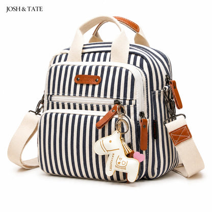 Josh & Tate - CarryAll™ Convertible Baby Bag - Navy and white striped backpack with dog charm on a white background