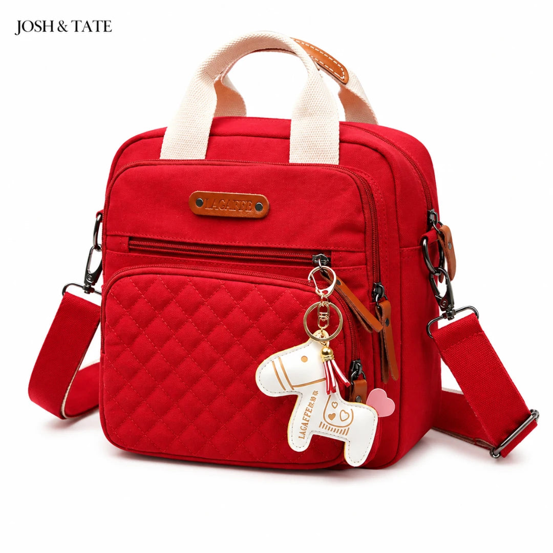 Josh & Tate - CarryAll™ Convertible Baby Bag - Red quilted bag with a keychain on a white background, featuring the brand 'JOSH & TATE'.