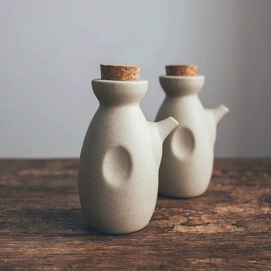 Josh & Tate - Ceramic Condiment Storage Set - Two ceramic jars with cork lids on a wooden surface