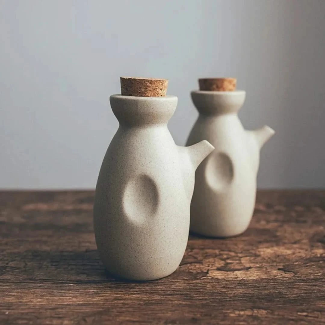 Josh & Tate - Ceramic Condiment Storage Set - Two ceramic jars with cork lids on a wooden surface