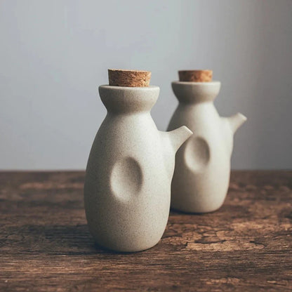 Josh & Tate - Ceramic Condiment Storage Set - Two ceramic jars with cork lids on a wooden surface