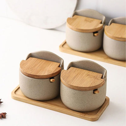 Set of ceramic containers with wooden lids on a wooden tray