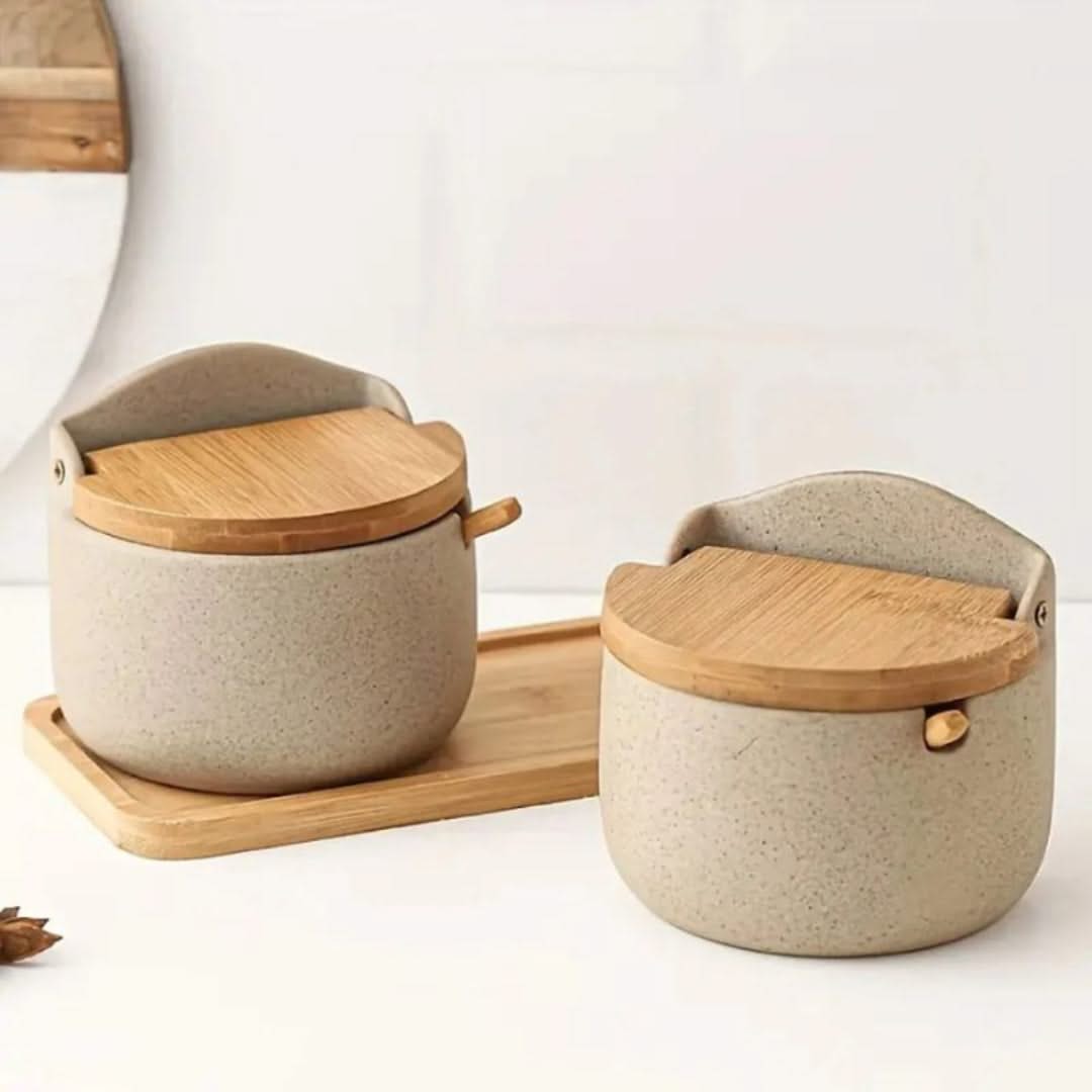 Two ceramic containers with wooden lids on a white surface