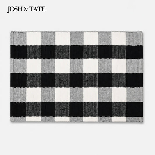 Josh & Tate - CheckMate™ Buffalo Plaid Cotton Rug - Black and white checkered rug with 'JOSH & TATE' branding on a light gray background