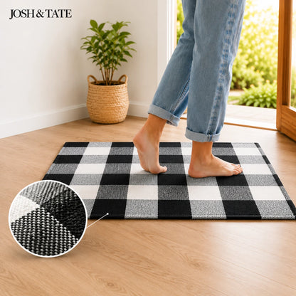 Josh & Tate - CheckMate™ Buffalo Plaid Cotton Rug - Person stepping onto a black and white checkered rug with 'Josh & Tate' branding.