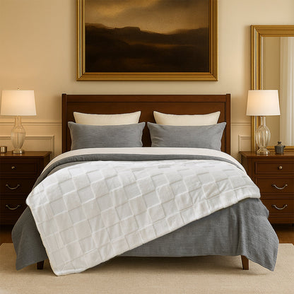 Bedroom with wooden bed, white and gray bedding, and two lamps on nightstands.