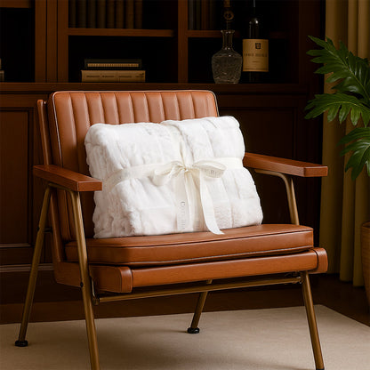 Brown leather chair with a white blanket and bow in a room setting.