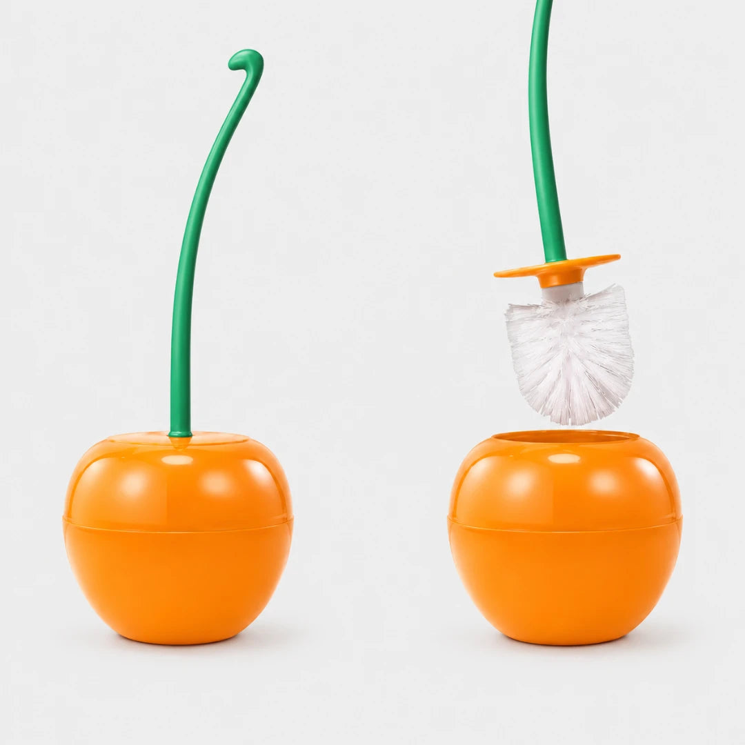 Josh & Tate - CherryPop™ Toilet Brush & Holder - An orange toilet brush holder shaped like a citrus fruit, with a green stem and a white-and-green brush shown both assembled and removed, on a light gray background.
