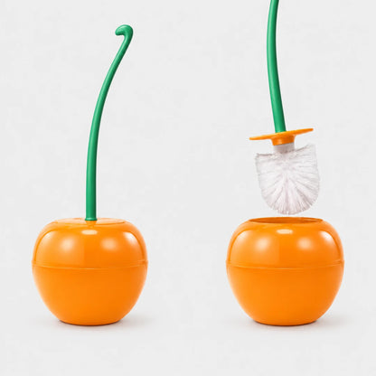Josh & Tate - CherryPop™ Toilet Brush & Holder - An orange toilet brush holder shaped like a citrus fruit, with a green stem and a white-and-green brush shown both assembled and removed, on a light gray background.
