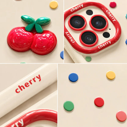 Josh & Tate - CherryPop™ iPhone Case - A collage showing a glossy cherry-themed phone case or camera surround accessory. The design features a 3D red cherry with green leaves on the back, a red camera-ring border printed with the word 'cherry', and scattered colorful circular accents in blue, yellow, green, red, and pink on a warm cream background.